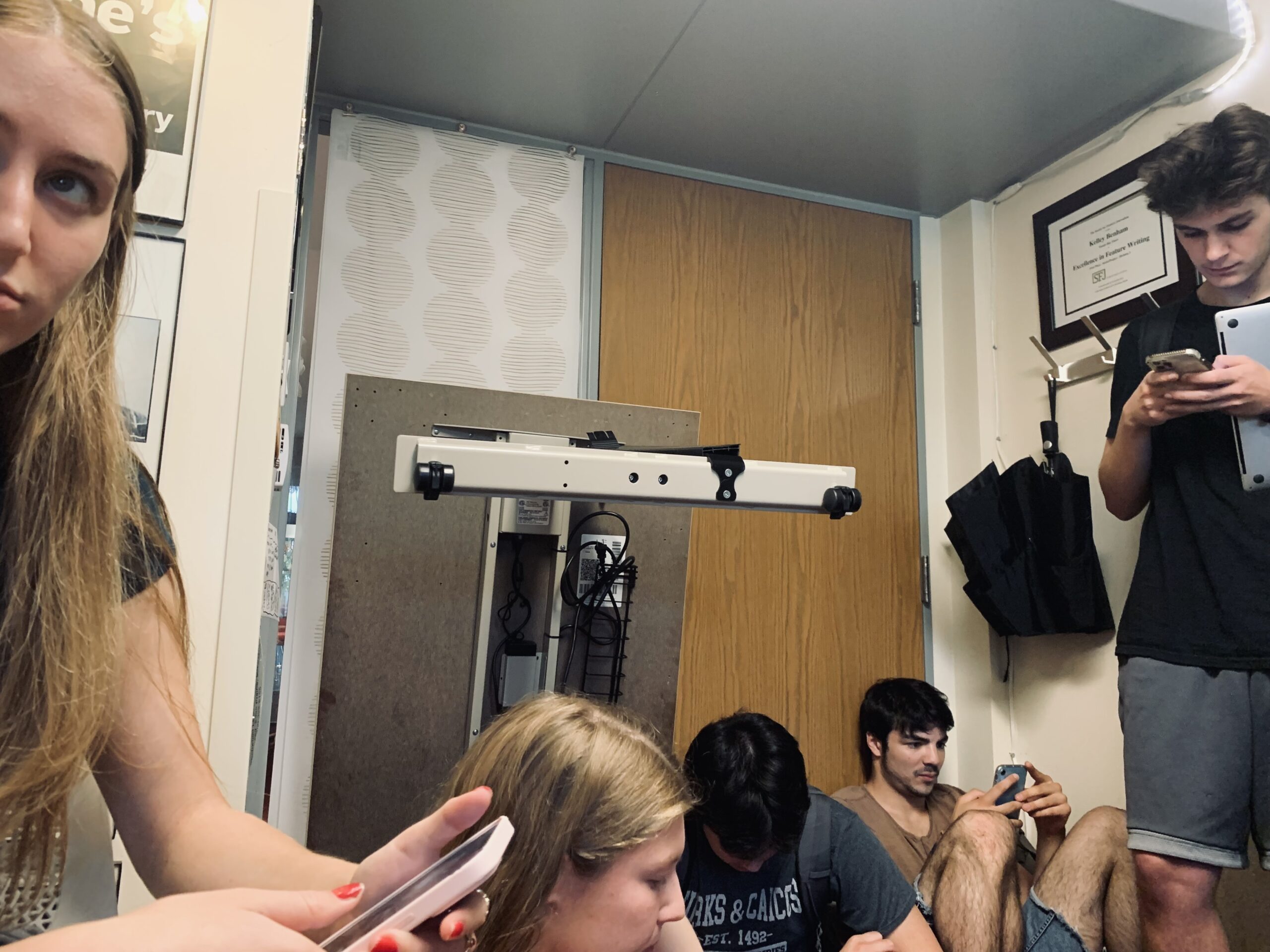 Students look at their phones while locked down inside a professors' office