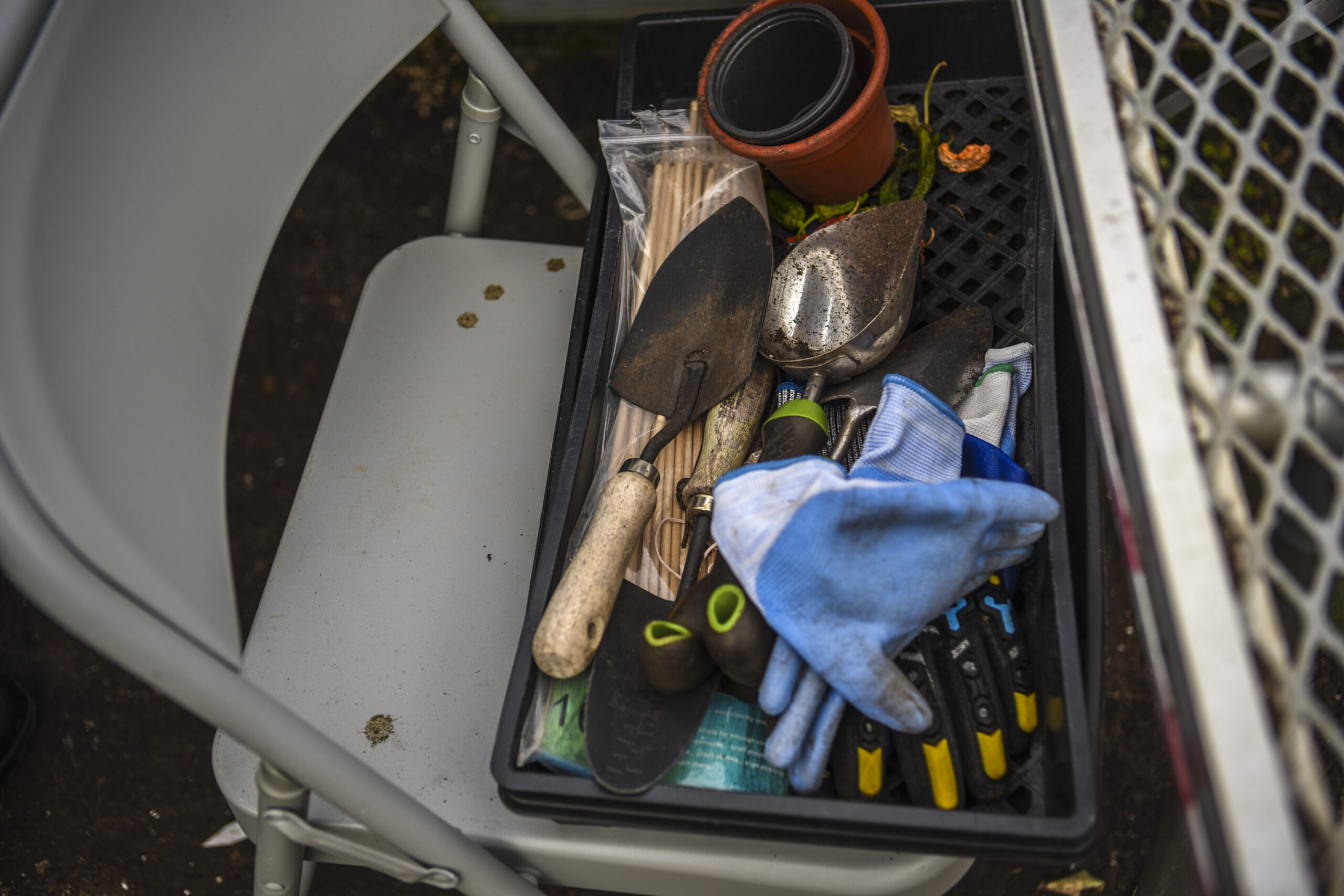 A collection of gardening tools sitting in a folding chair